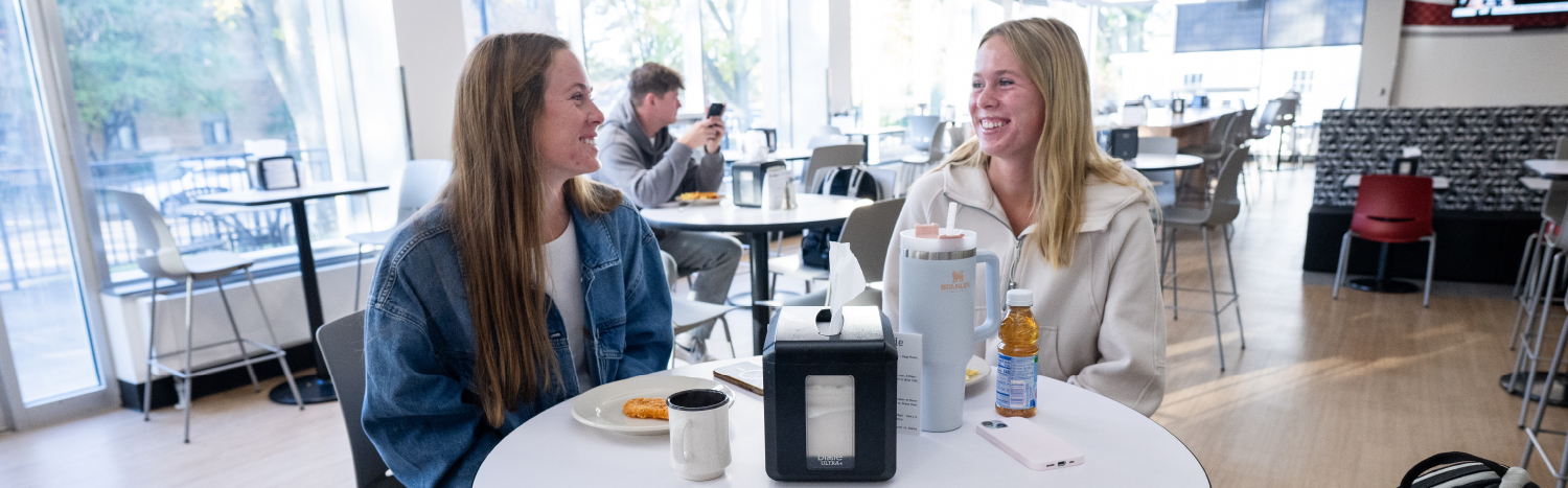 two female students sitting in dining hall