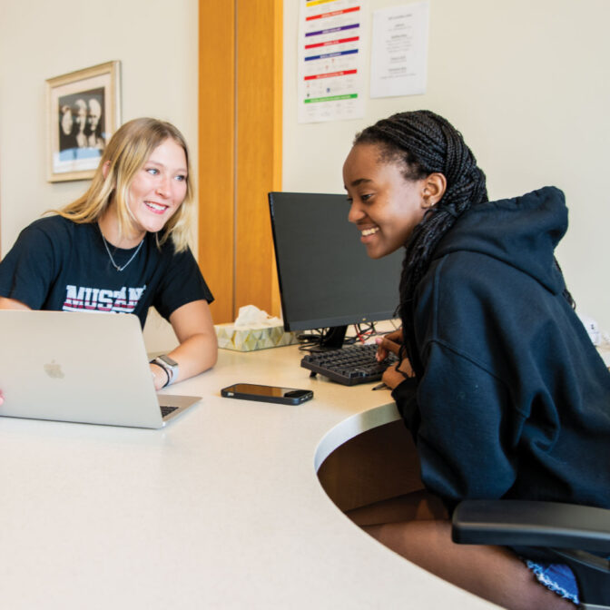 students talking over computer