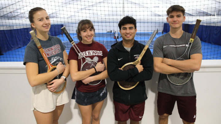 Four members of the tennis team pose for a photo.