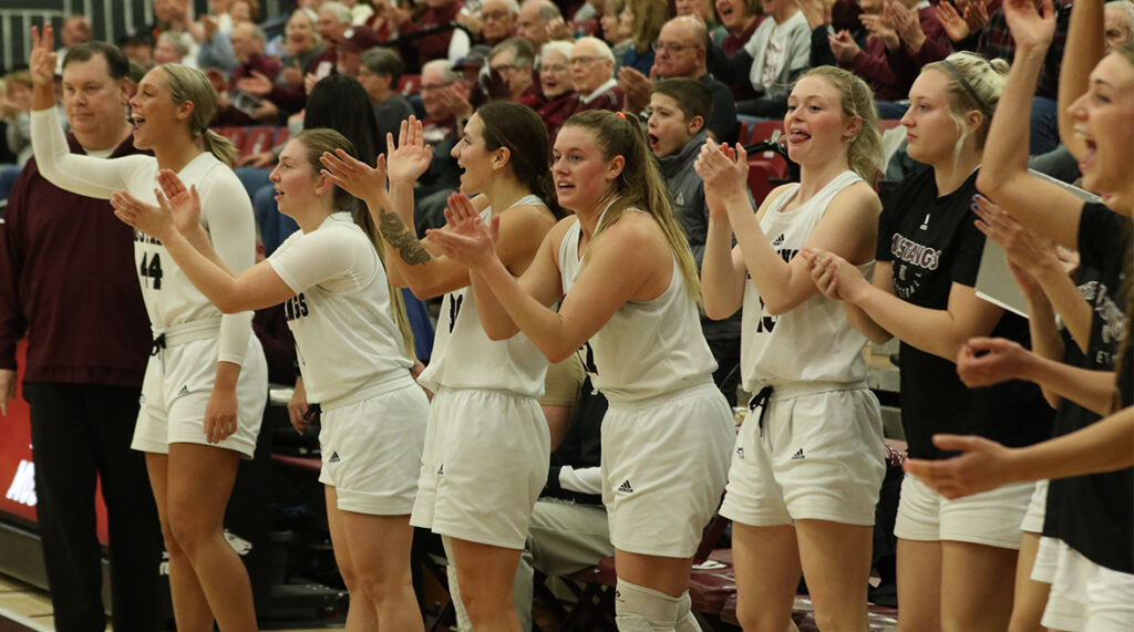 The women's basketball team celebrates a teammates' basket