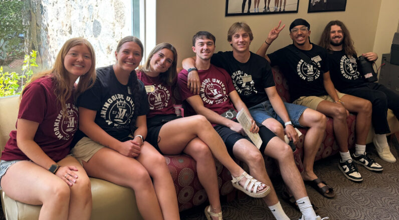 A group of students smiling for a picture during summer enrollment days.