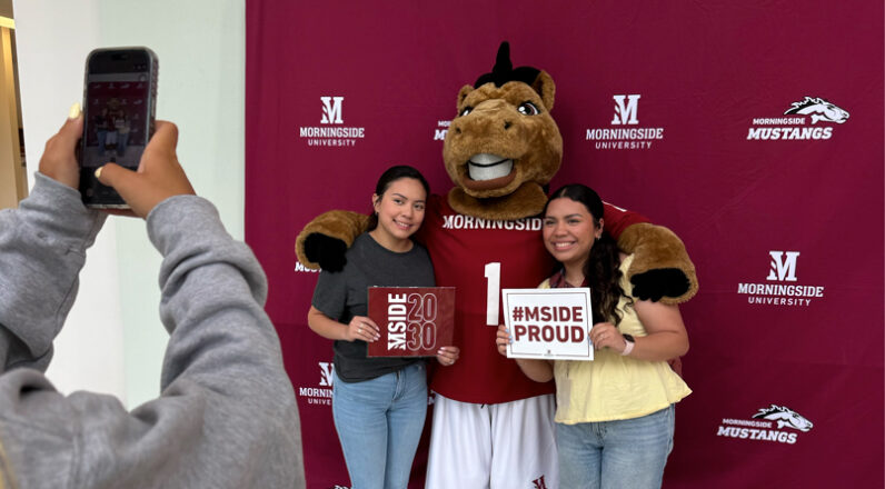 2 students smiling with Monte the Mustang on Summer Enrollment Days.
