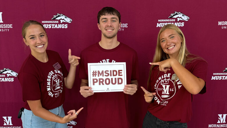 Students holding up a #MsideProud sign during summer enrollment days